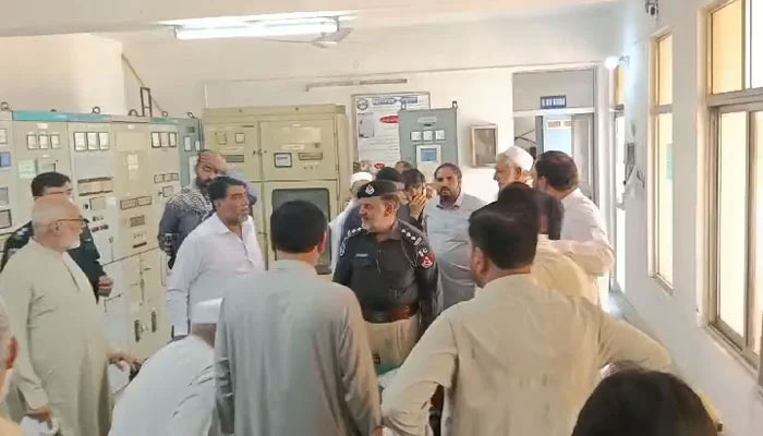 Police officer is seen trying to calm down citizens at the Hazarkhawani grid station in Peshawar on May 25, 2024, in this still taken from a video. — YouTube/Geo News Live