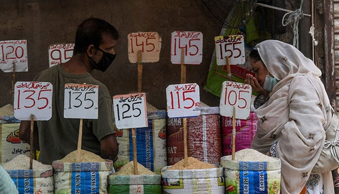 A woman inspects rice at a  stall in a market. — AFP/file