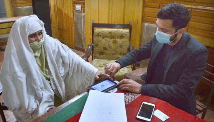 A BISP officer verifies the NIC and biometric of deserving people during the distribution of relief funds through Benazir Income Support Programme  — APP/File