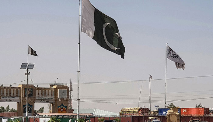 Pakistani flags and Afghan Taliban flag flutter on their respective border sides as seen from the Pakistan-Afghanistan border crossing point in Chaman on August 18, 2021. — AFP