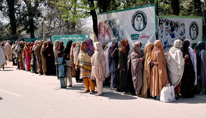 A large number of women stand in a queue to draw money from Benazir Income Support Programme (BISP) beneficiaries outside Benazir One Window Center. — APP/File