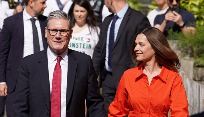 UK PM Keir Starmer and his wife Victoria Starmer walk outside a polling station during the general election in London, Britain, July 4, 2024.— Reuters