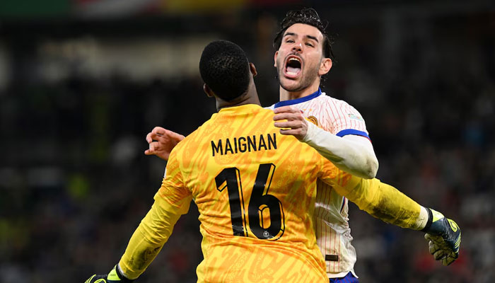 Frances Mike Maignan and Theo Hernandez celebrate after winning the penalty shoot-out during Euro 2024 quarter final match against Portugal at Hamburg Volksparkstadion, Germany on July 5, 2024. — Reuters