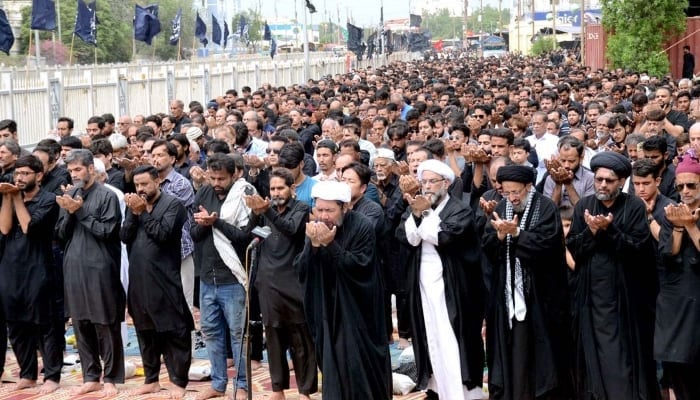 Mourners offering dua after performing Namaz during main procession of Ashura on 9th Muharram on MA Jinnah Road on July 28, 2023. —APP