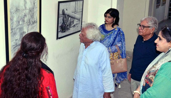 Visitors take keen interest in painting during Arts Drawing and Painting Exhibition 2024 at Coopera Art Gallery Mall Road in Lahore on July 6, 2024. — PPI