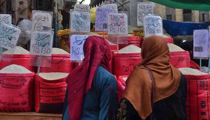 In this picture taken on January 10, 2023, women check rice prices at a main wholesale market in Karachi. — AFP