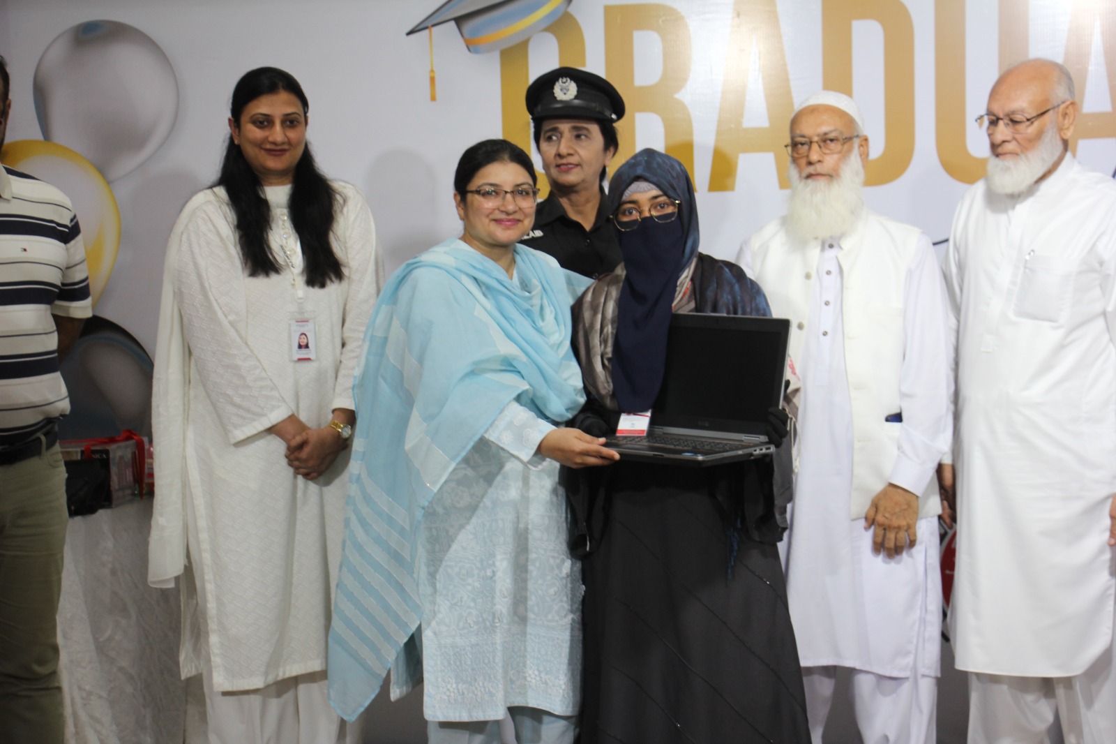 A student receives a laptop during the certificate awarding ceremony after completion of courses at AIET. — Supplied