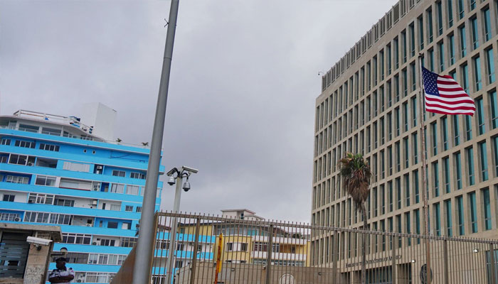 The U.S flag flies next to a security officer guarding the U.S. embassy in Havana, Cuba, December 12, 2023. — Reuters