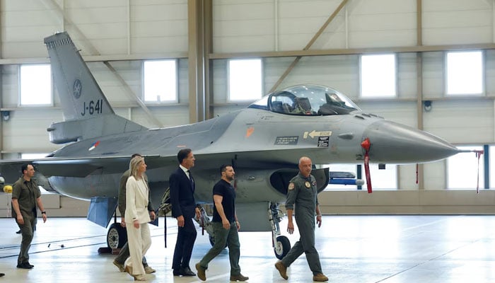 Ukrainian President Volodymyr Zelenskiy and Dutch Prime Minister Mark Rutte walk near an F-16, in Eindhoven, Netherlands, August 20, 2023. — Reuters