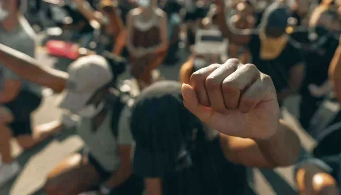 A representational image of a person showing a fist during a protest. — Unsplash/File