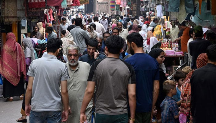 In this picture taken on April 16, 2023, people throng a market area in Lahore. — AFP