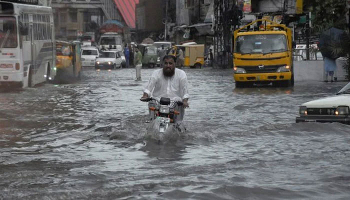 A man rides on a motorcycle amid flood waters along a road during the monsoon season in Rawalpindi, Pakistan July 19, 2023. — Reuters