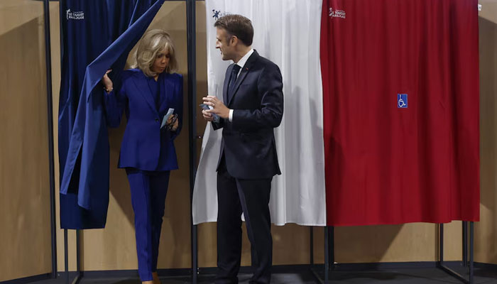 French President Emmanuel Macron (R) and French First Lady Brigitte Macron (L) vote at a polling station in the second round of French parliamentary elections in Le Touquet-Paris-Plage, France, on July 7, 2024. — Reuters