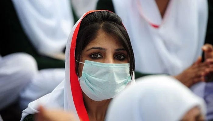 In this image, a Pakistani paramedic sits with others at a protest rally. — AFP/File