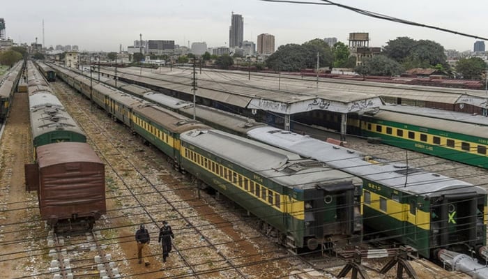 Policemen walk along trains stationed on a deserted platform at Karachi Cantonment railway station. — AFP/File