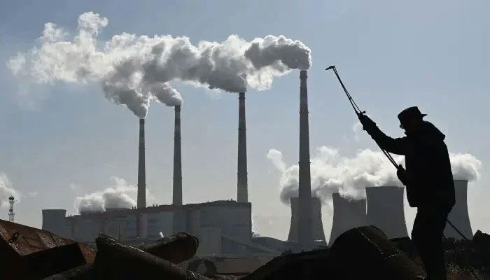 A worker cutting steel pipes near a coal-powered power station. — AFP/file