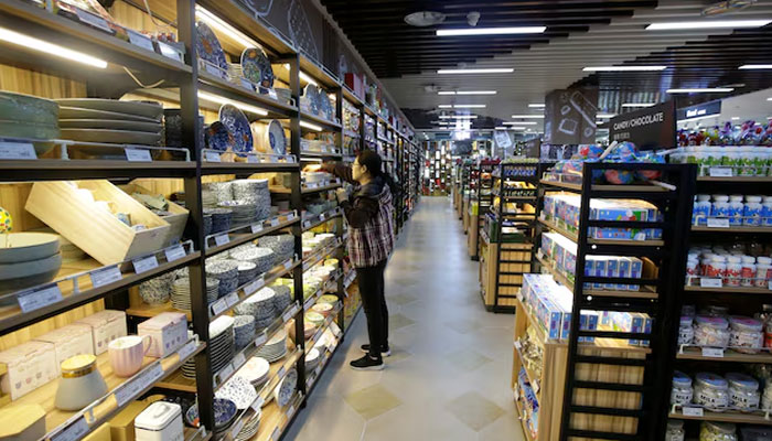 A woman selects a bowl at a supermarket in Beijing, China. — Reuters/file