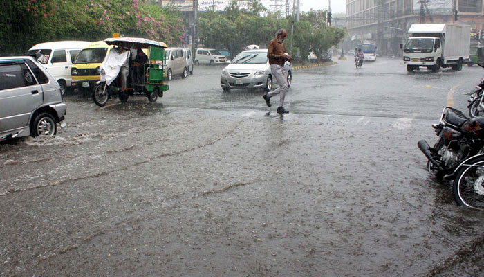 Commuters pass through a road during heavy downpour of monsoon season, at Shimla Hill in Lahore on July 10, 2024. — PPI