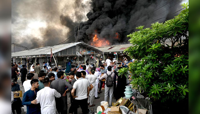 People gather on the spot after a fire erupted in weekly bazaar in H-9 sector in Islamabad on July 10, 2024. — APP