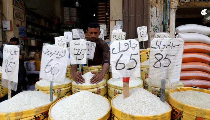 vendor arranges different types of rice, with their prices displayed, at his shop in a wholesale market in Karachi on April 2, 2019. —  Reuters