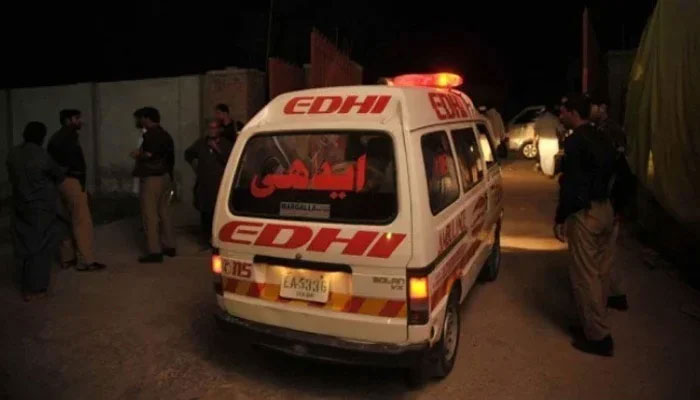 This image shows an Edhi ambulance passing by police officials. — AFP/file