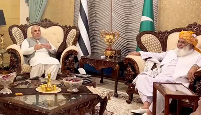 PTIs senior leader Asad Qaiser (left) during a meeting with JUI-F chief Maulana Fazlur Rehman in Islamabad, on October 26, 2023, in this still taken from a video. — X/@juipakofficial