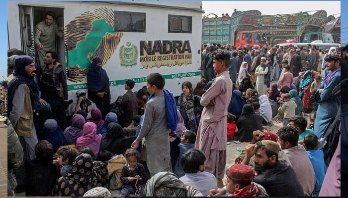 Afghan refugees gather in front of the NADRA vans for bio-metric verification before their departure to Afghanistan, at a holding centre near the Pakistan-Afghanistan border in Chaman on November 1, 2023. — AFP