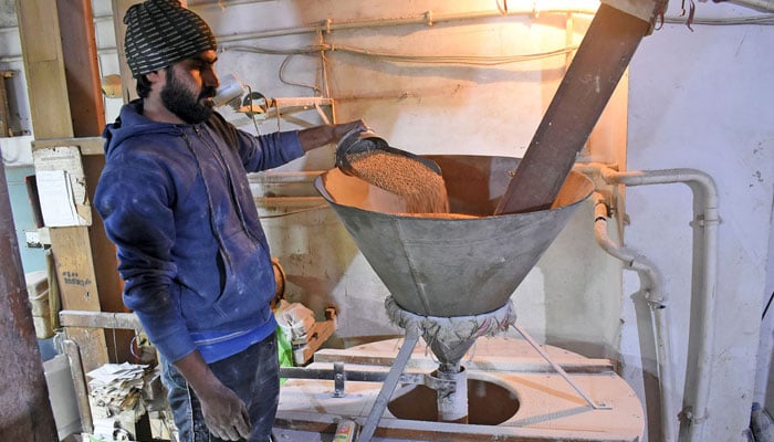 A worker busy in preparing wheat flour in his flour mill at Gawalmandi area in Lahore on January 23, 2023. — Online