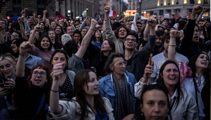 People celebrate during an election night rally following the first results of the second round of France´s legislative election at Republique Square in Paris on July 7, 2024. — AFP