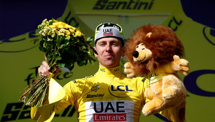 UAEs Tadej Pogacar celebrates on the podium wearing the yellow jersey after winning Tour de France stage 15 on  July 14, 2024. — Reuters