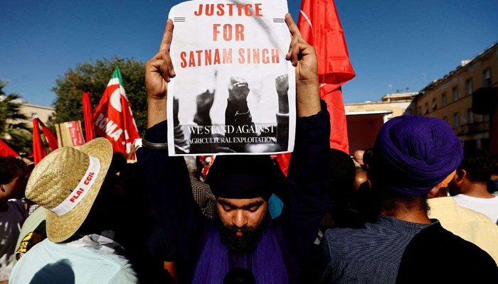 A protester holding a placard during a demonstration against the death of Indian labourer Satnam Singh. — Reuters/file