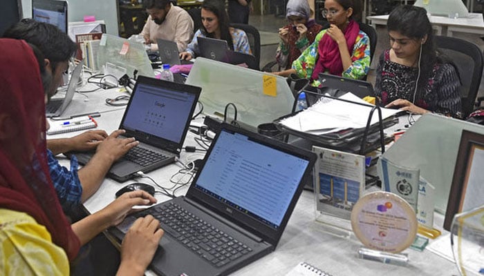 People work at their stations at the National Incubation Centre (NIC) in Lahore, Pakistan. — AFP/File