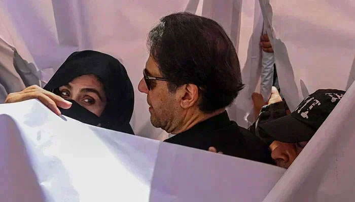 PTI founder Imran Khan with his wife Bushra Bibi arrive to appear before LHC. — AFP/file