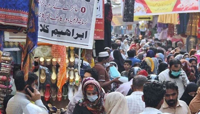 Pakistanis walking on the streets of Karachi near a local market. — PPI/File