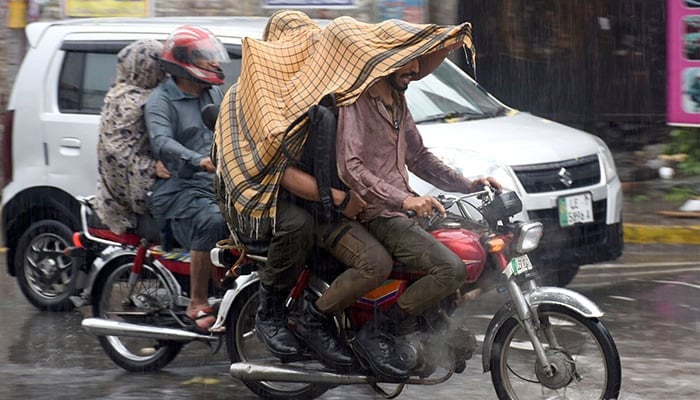 Commuters make their way through heavy monsoon rains in Lahore on July 12, 2024. — Online