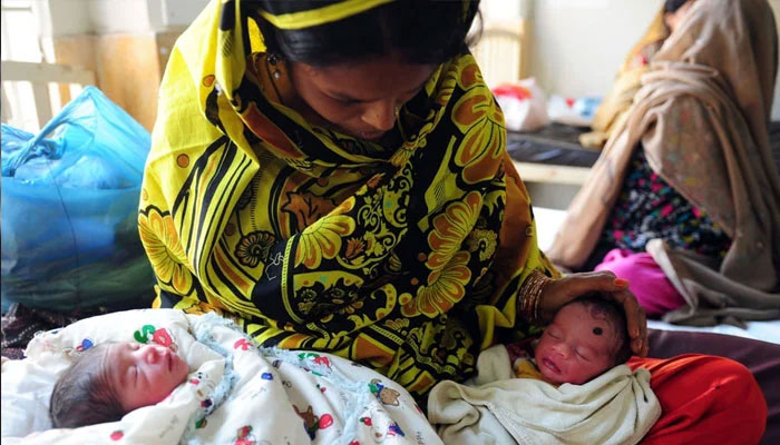 A representational image showing a mother caring for her new-born babies. — AFP/File