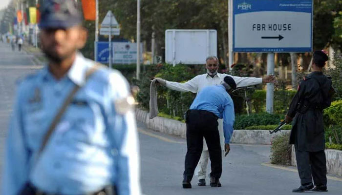 An Islamabad police personnel conduct a pat-down check on  a citizen amid tight security in the federal capital. — AFP/File