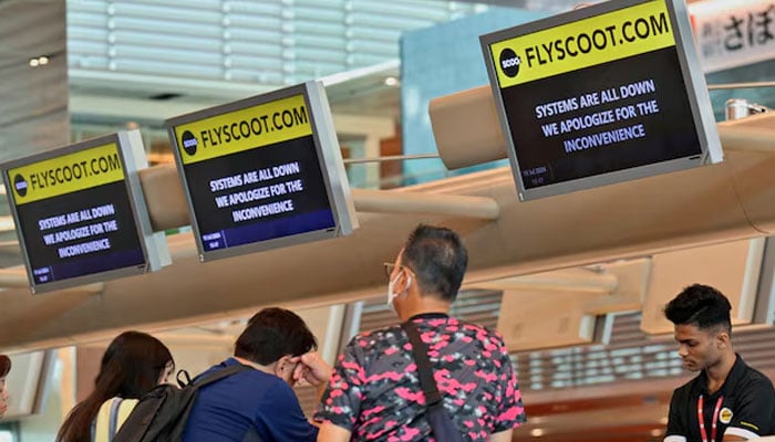 Passengers wait to be checked-in manually at Changi Airport Terminal 1 in Singapore after a global IT system outage, July 19, 2024. — Reuters