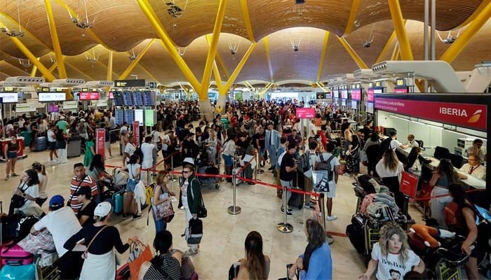 Passengers stand in terminal 4 of Adolfo Suárez Madrid–Barajas Airport in Madrid on July 19, 2024. —AFP