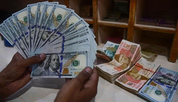 A foreign currency dealer counts US dollars at a shop in Karachi on May 19, 2022. — AFP/file