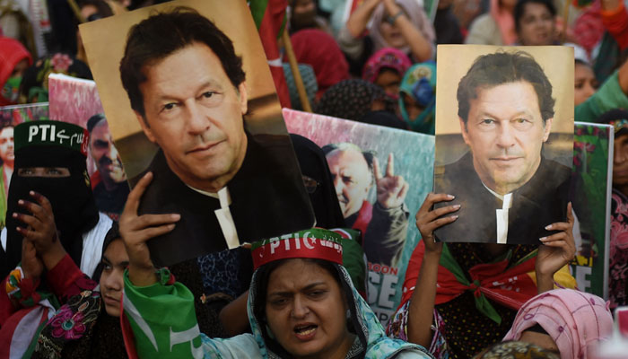 PTI supporters carry placards displaying portraits of party founder and former prime minister Imran Khan during a protest in Karachi. — AFP/File