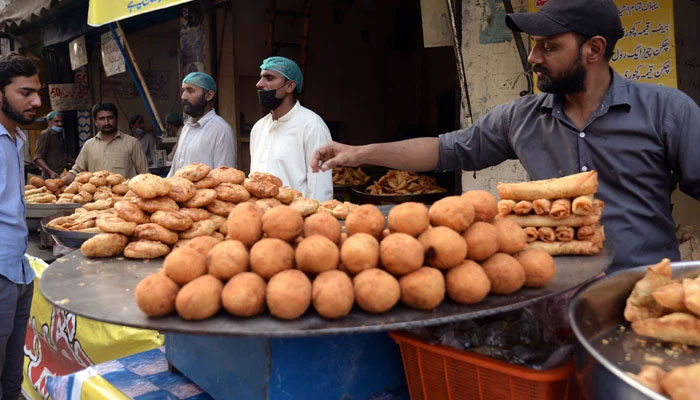 Vendors display samosas, kachoris, and chicken rolls to attract customers on March 12, 2024. — APP