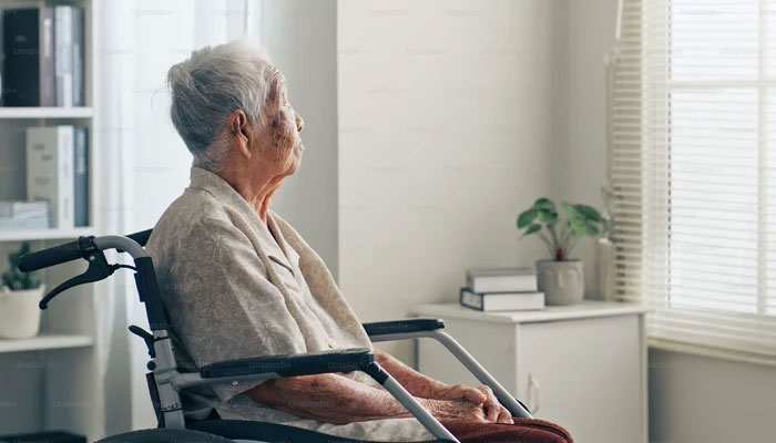 A representational image of an old person sitting in a wheelchair. — Unsplash