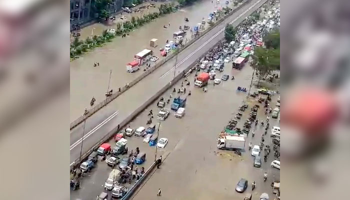 Commuters face difficulties in transportation due to stagnant rainwater due to poor sewerage system caused by heavy downpours of monsoon season, at Nazimabad area in Karachi on July 20, 2024. — PPI