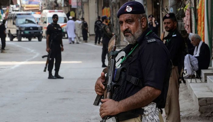 Police stand guard ahead of a Muharram procession in Peshawar on August 7, 2022. — AFP