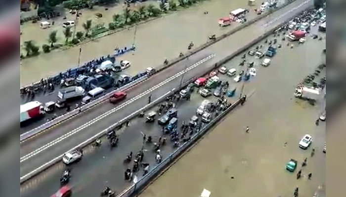 Commuters face difficulties in transportation due to stagnant rainwater due to poor sewerage system caused by heavy downpour of monsoon season, at Nazimabad area in Karachi on July 20, 2024. — PPI