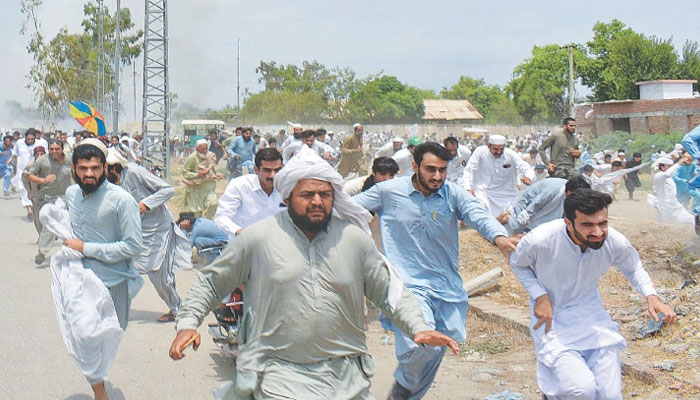 People scatter after shots were fired during a peace march held in Bannu to oppose the military operation, on Friday. — AFP