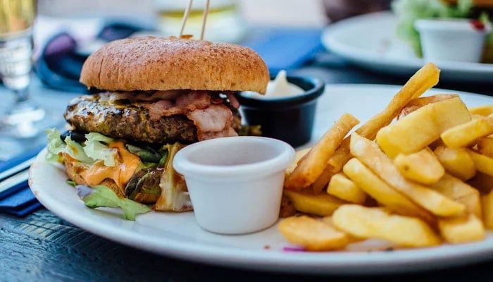 This representational image shows a burger and french fries. — Unsplash/File