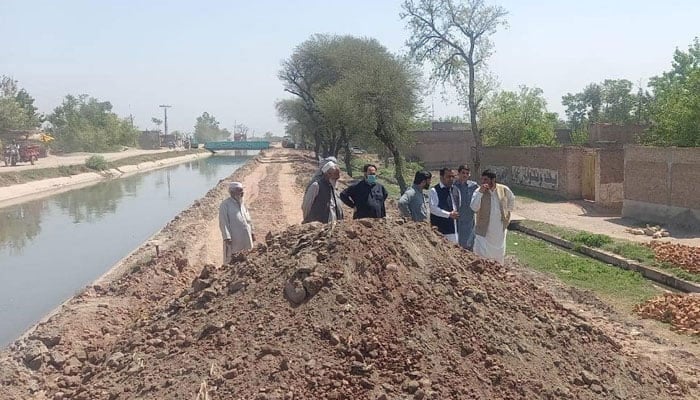 This representational image shows people standing near Canal. — Facebook/Warsak Canals Division, Irrigation Department, KP/File