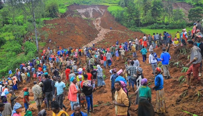 People standing at the bottom of a landslide that occurred in the Geze-Gofa district in Ethiopia on July 22, 2024, — AFP